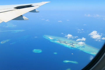 Fototapeta na wymiar Maldives islands top view and airplane wing