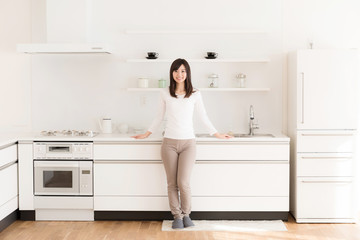 Fototapeta na wymiar attractive asian woman relaxing in kitchen