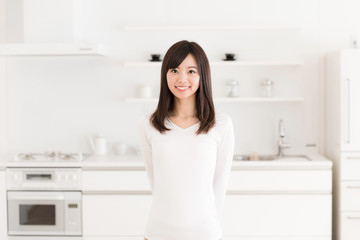 attractive asian woman relaxing in kitchen