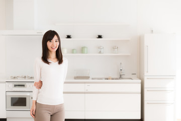 attractive asian woman relaxing in kitchen