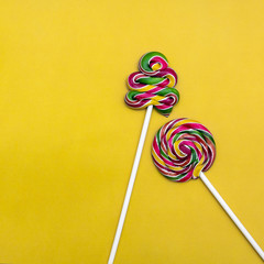 Lollipop Flat lay Minimal concept Two colorful lollipops on a yellow background Round lollipop and...