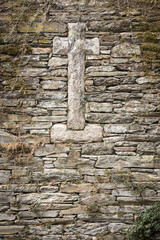 a Stone made cross on a stone made wall