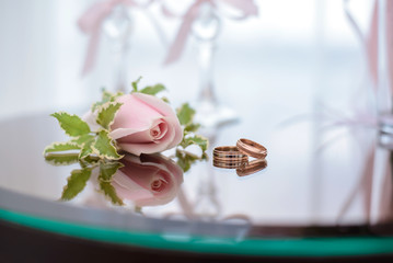 Wedding rings lie next to the buttonhole