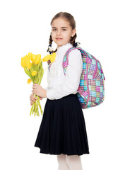 A schoolgirl with a bouquet of flowers and a backpack on her sho