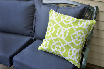 Green and white pillow on rod iron outdoor sofa 
