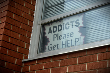 Addicts please get help sign in building of homeless shelter in urban area