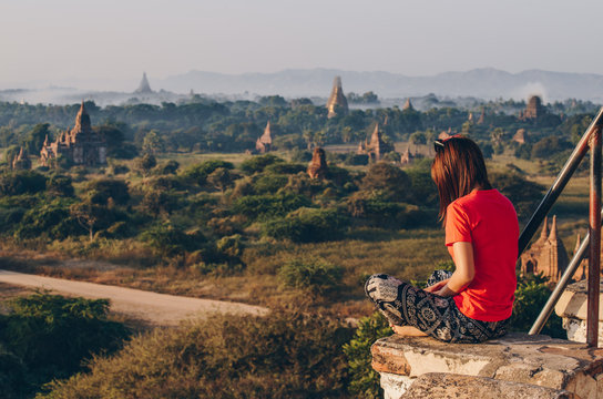 Tourist sitting on the pagoda with spectacular landscape of Bagan plain land of thousand pagoda in Mandalay region of Myanmar.