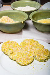 Applying cornmeal dredge to tomato slices