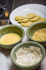 Applying cornmeal dredge to tomato slices