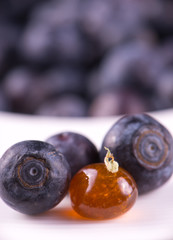 Marijuana oil concentrate aka shatter on a plate with with blueberries