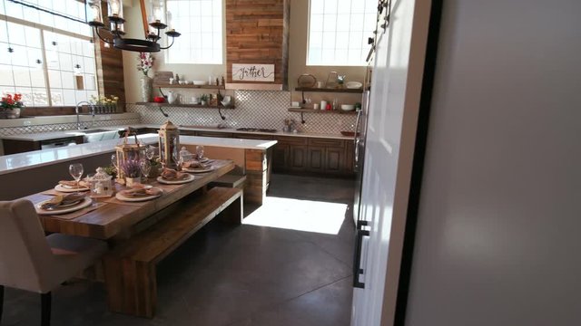 Revealing Modern Kitchen Scene from Behind a Wall. a modern rustic industrial kitchen scene and dining room table are revealed from behind a wall, panning left and rising up
