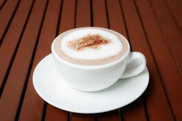 cup of hot chocolate on wooden table background