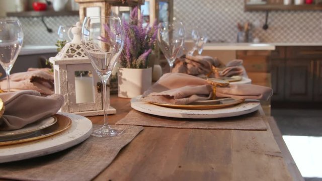 Dining Room Table Setting Detail Corner. view rises and lowers on a rustic modern wood dining room table setting. Plates, napkins, glasses and centerpieces
