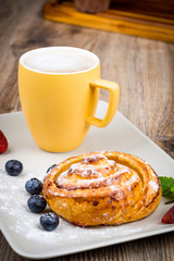Cup of coffee and pastry on wooden background