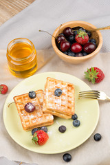 Photo of waffles with berries on wooden background