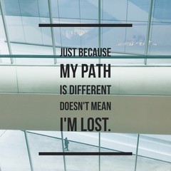 Inspirational Motivational quote "just because my path is different doesn't mean I'm lost" on window background.