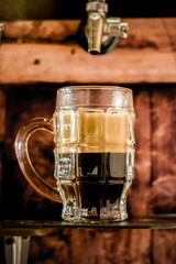 Delicious craft beer in a pint glass on wooden background