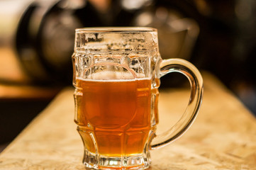 Close up of a blonde craft beer filled into a pint glass on wooden table