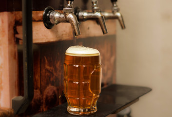 Delicious blonde craft beer filled into a pint glass on wooden table