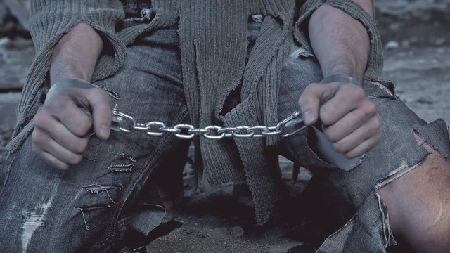 a prisoner in chains on his knees