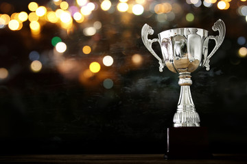 low key image of trophy over wooden table and dark background