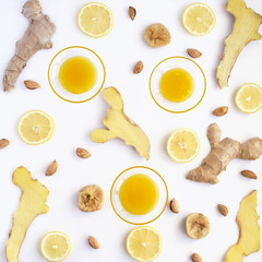 Pattern from the cut root of ginger, slices of lemon and plates with honey. Composition from food on a white background. Food background pattern.