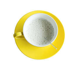 Hot milk in yellow cup isolated.