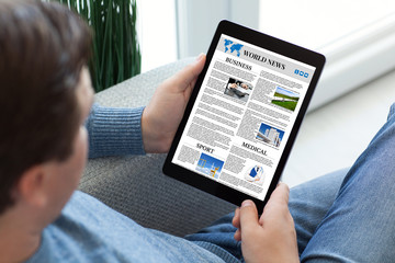 man in jeans holding tablet computer with app world news