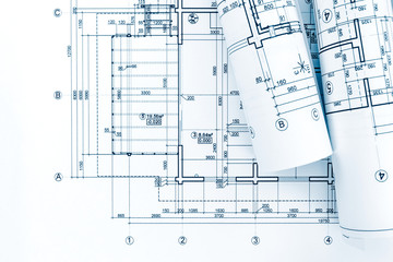 architect workplace with rolls of blueprints and technical drawings