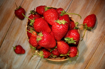 красивая красная клубника лежит на деревянных досках      