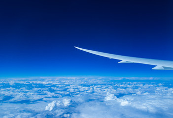 airplane wing above cloud in blue sky