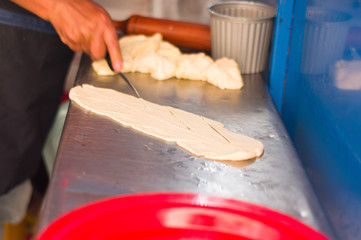 woman preparing the mass to cook a homemade fritters in the market