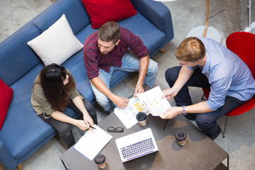 Three People Discussing Business Strategy in Cafe