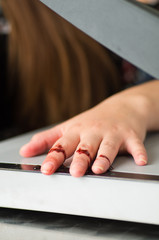 Close up of a woman using a paper cutter, had an accident and cut her fingers