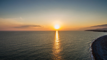 Obraz premium sunset over water surface of the sea from the height of bird flight