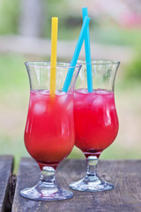 Two cocktail glasses with a bright red cocktail. Ice in a glass. Refreshing drink. Thirst quenching
