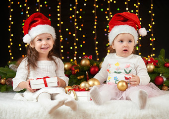 child girl portrait in christmas decoration, happy emotions, winter holiday concept, dark background with illumination and boke lights