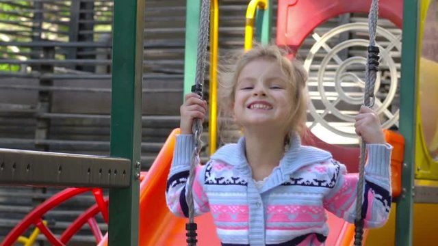 Little girl on playground. Slow motion