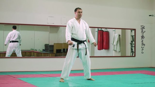 The sportsman in white clothes performing a karate 4k