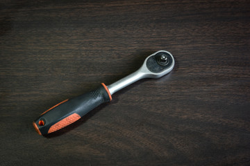 ratchet wrench lying on wooden table