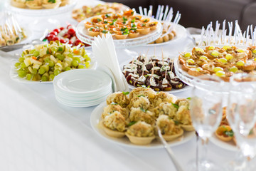 A small table with a delicious buffet of canapes, caviar, sandwiches
