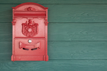 Red mail box on the green wooden background. vintage style with copy space.