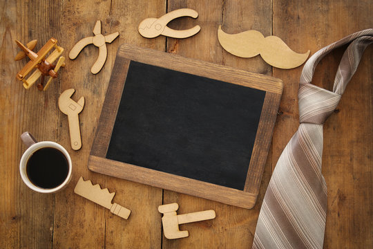 top view image of fathers day composition with wooden shape tools, necktie , cup of coffee and blackboard