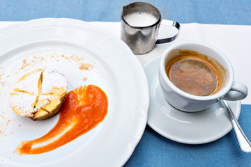 Viennese Apple strudel with fruit sauce on a plate. not a classic shape in a unique way. a Cup of coffee and a warm frothed milk