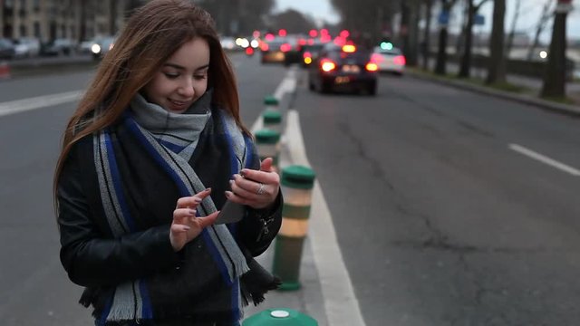 woman using smartphone on the street, girl in scarf with mobile phone
