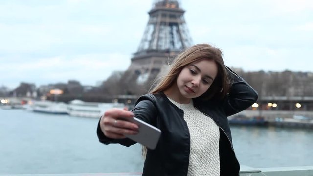 young woman tourist taking selfie photo with Eiffel Tower in Paris, attractive caucasian girl doing selfy on smart phone