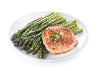 Cooked asparagus with meat steak on a white plate
