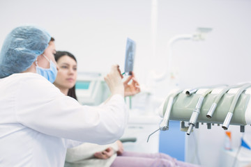 Doctor talking with patient and showing a radiograph in stomatology clinic