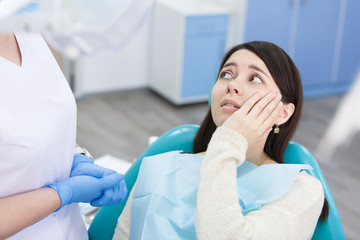 Unhappy patient having a toothache in dental clinic