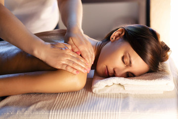 Body massage and spa treatment in modern salon with candles